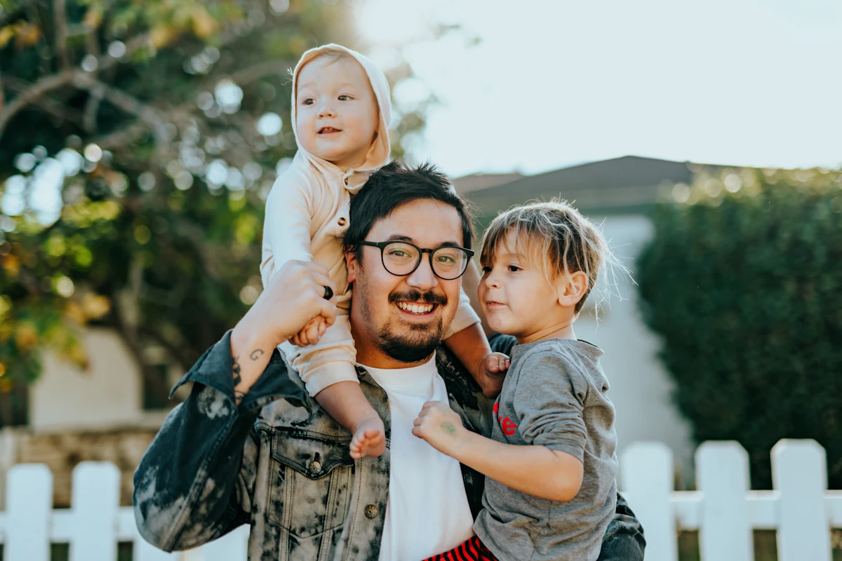 Father with two young children outside their home
